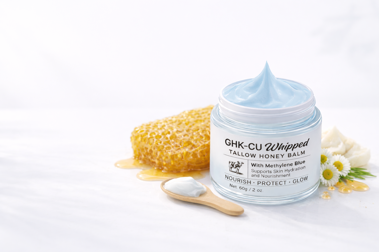 Jar of GHK-CU Whipped Tallow Honey Balm with a wooden spoon and sponge on a white background